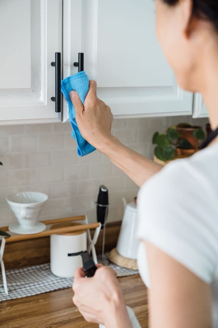 Cleaner wiping kitchen cabinets