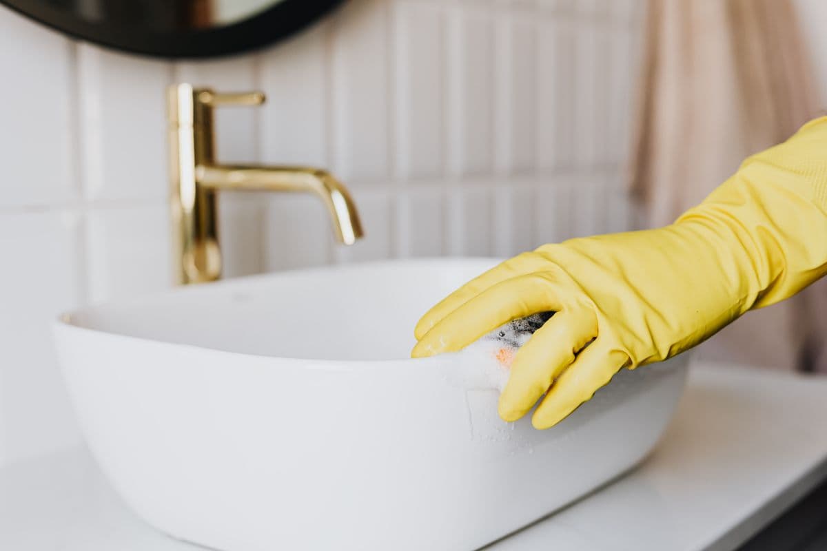 Cleaner wiping a bathroom sink